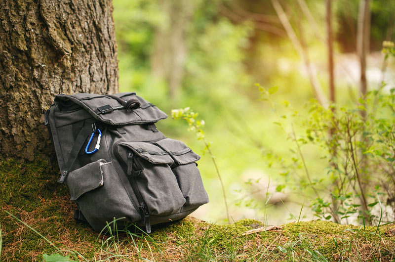 Image of a backpack on the floor of a forest